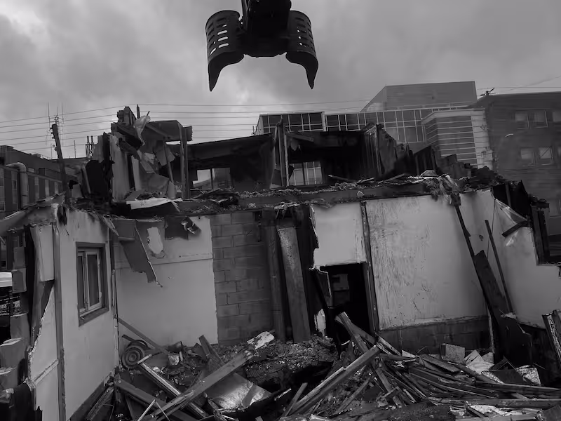 A powerful grapple attachment guides controlled demolition in progress by SSM Demolition & Contracting in Southern Ontario.